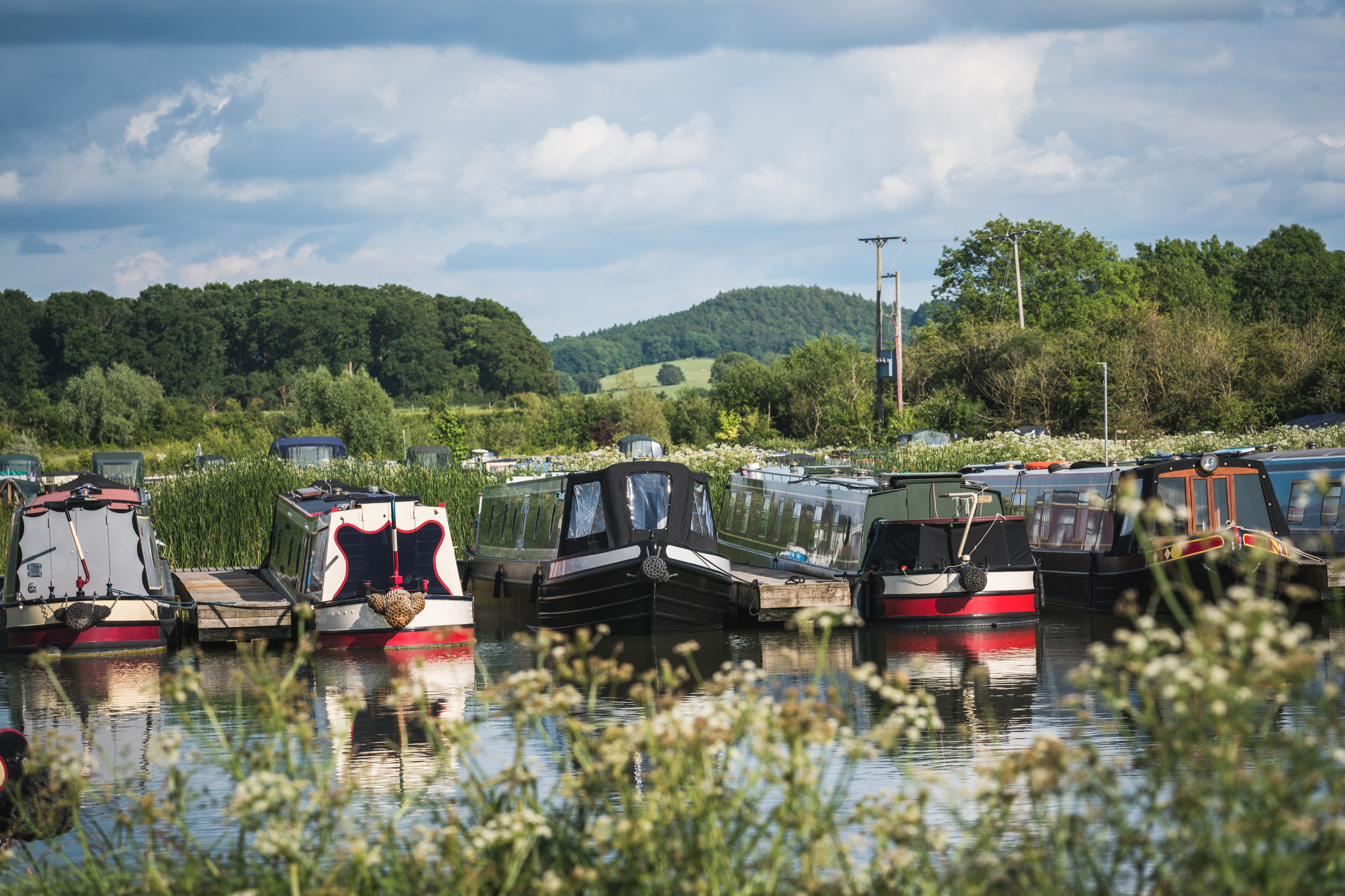 Narrowboats float on the water side by side.
