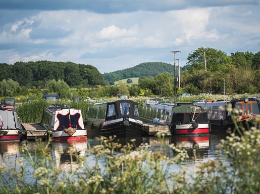 Narrowboats float on the water side by side.