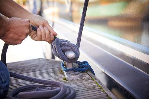 Rope being tied around cleat